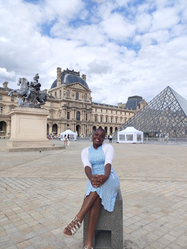 Martha sitting outside the Louvre Museum, sightseeing