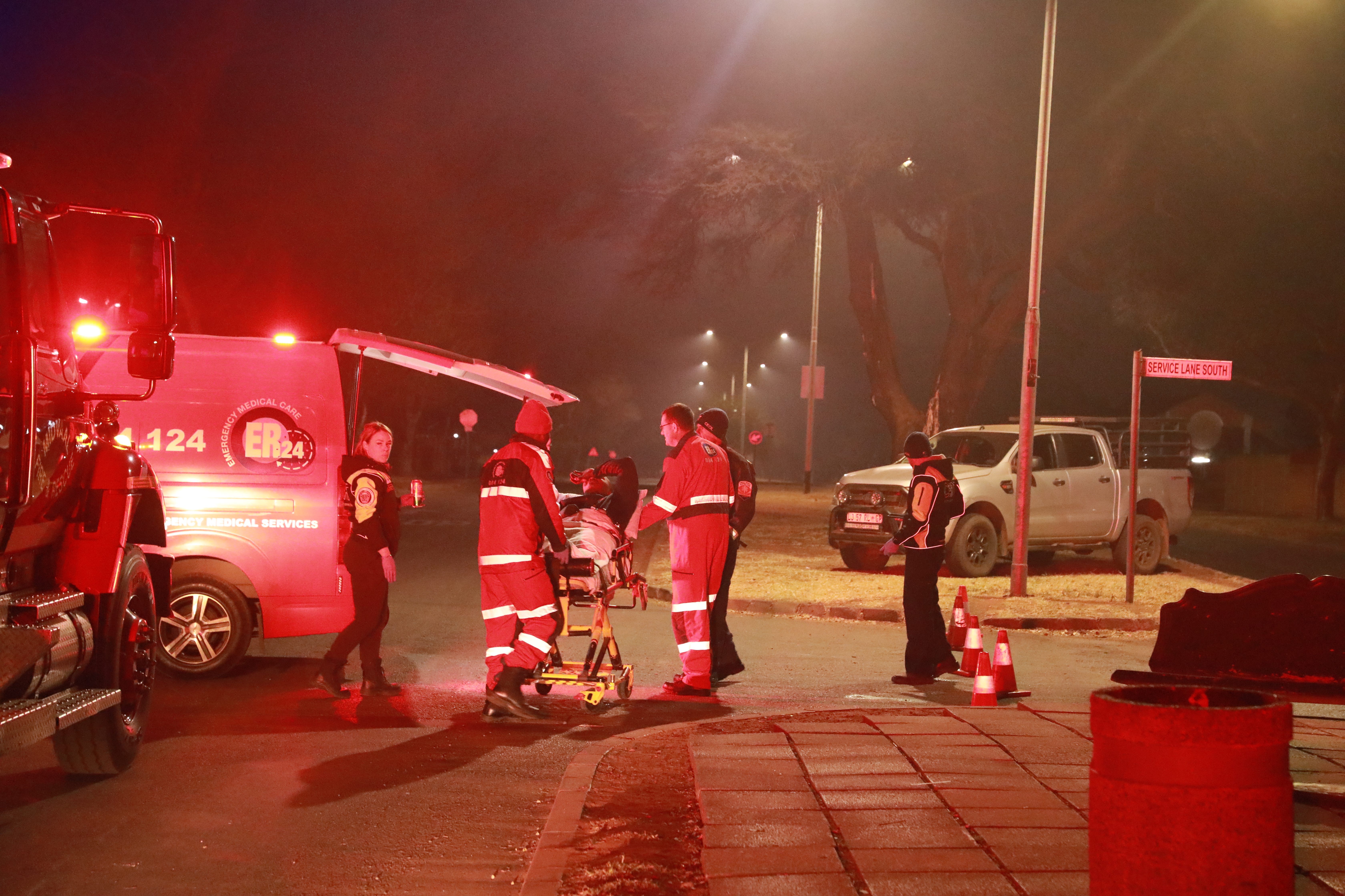ER24 Emergency Medical Services paramedics attending to a patient on a stretcher at the scene of the Meyerton CBD fire, 21 July 2026