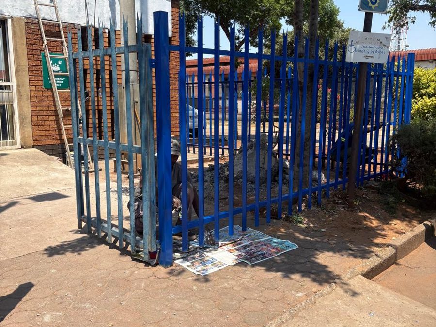 Painter at work on the palisade fence gate at Meyerton police station